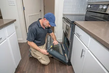 Repairman repairing range in Saskatoon