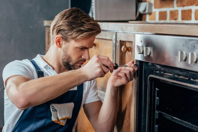 Repairman-Fixing-Oven-Stove,With-Screwdriver-In Calgary