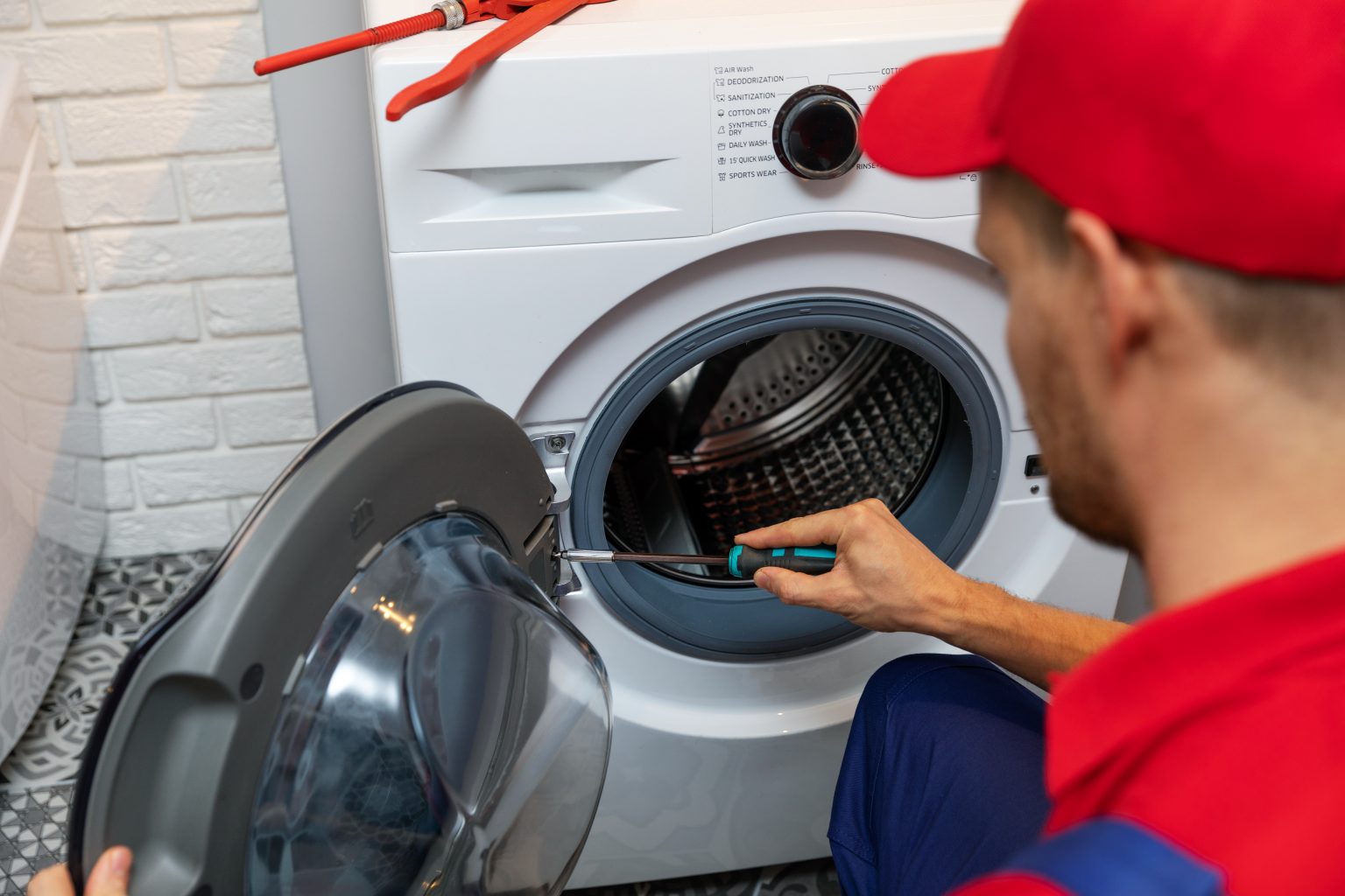 SMS-Appliances-Technician-With-Screwdriver-Repairing-Washing-Machine