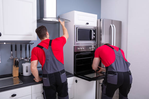 Two Male Technicians Fixing The Exhaust Hood And Oven In The Modular Kitchen